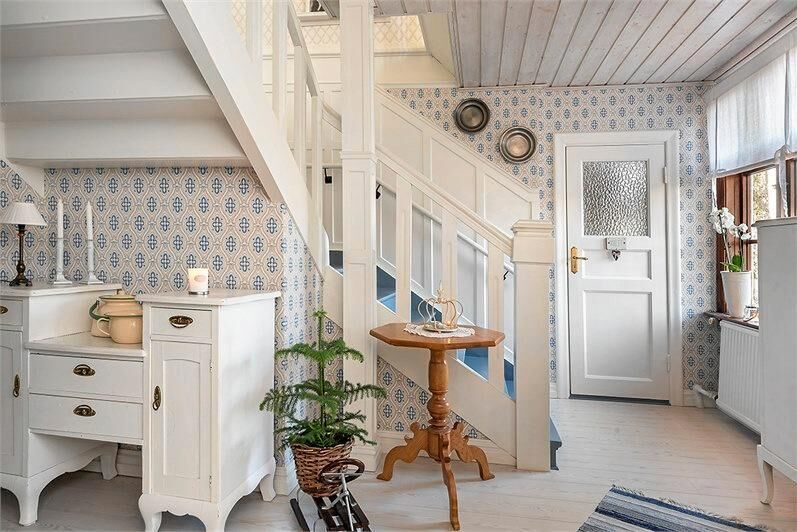 En vitmålad trapp leder upp till övervåningen.