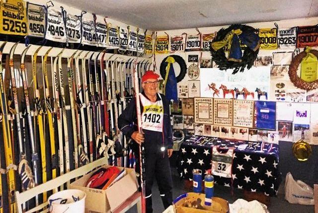 Börje Karlsson bland skidor och startnummer som han haft i Vasaloppet genom åren.