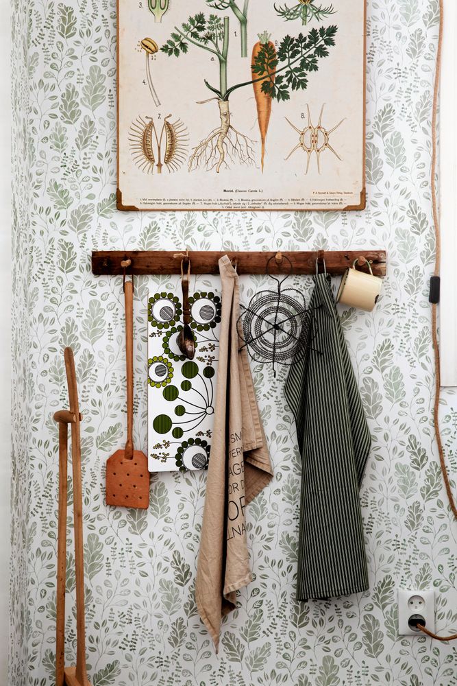 Grönmönstrad tapet och antik skolplansch är fina på köksväggen.