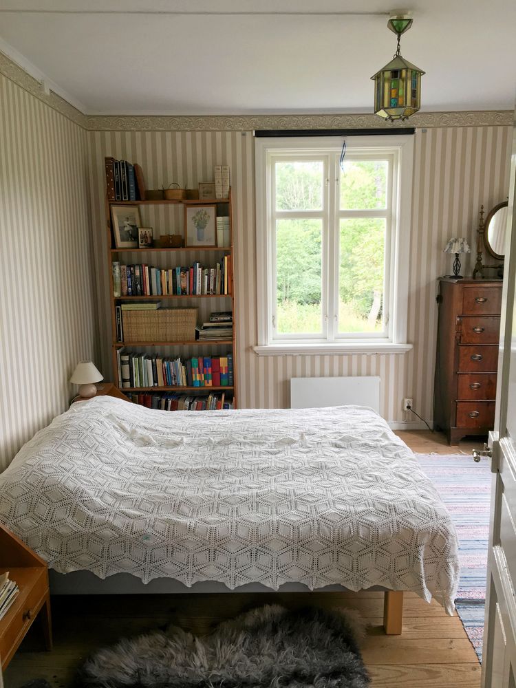 Kammaren bakom köket är mormor Margaretas rum. Vid huvudändan av sängen satt tidigare en dörröppning. ”Det var omöjligt att möblera kammaren med två dörrar och två fönster och dessutom blev köket nu dubbelt så stort tack vare den nya väggen”, säger Lovisa.