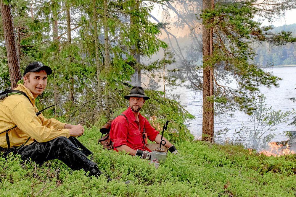 Magnus Melander från länsstyrelsen i Östergötland och naturvårdsbrännaren Johan Falck ser på medan branden tar sig och noterar hur den beter sig.