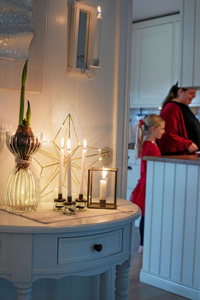 Levande ljus på hallbordet ger mysig stämning.