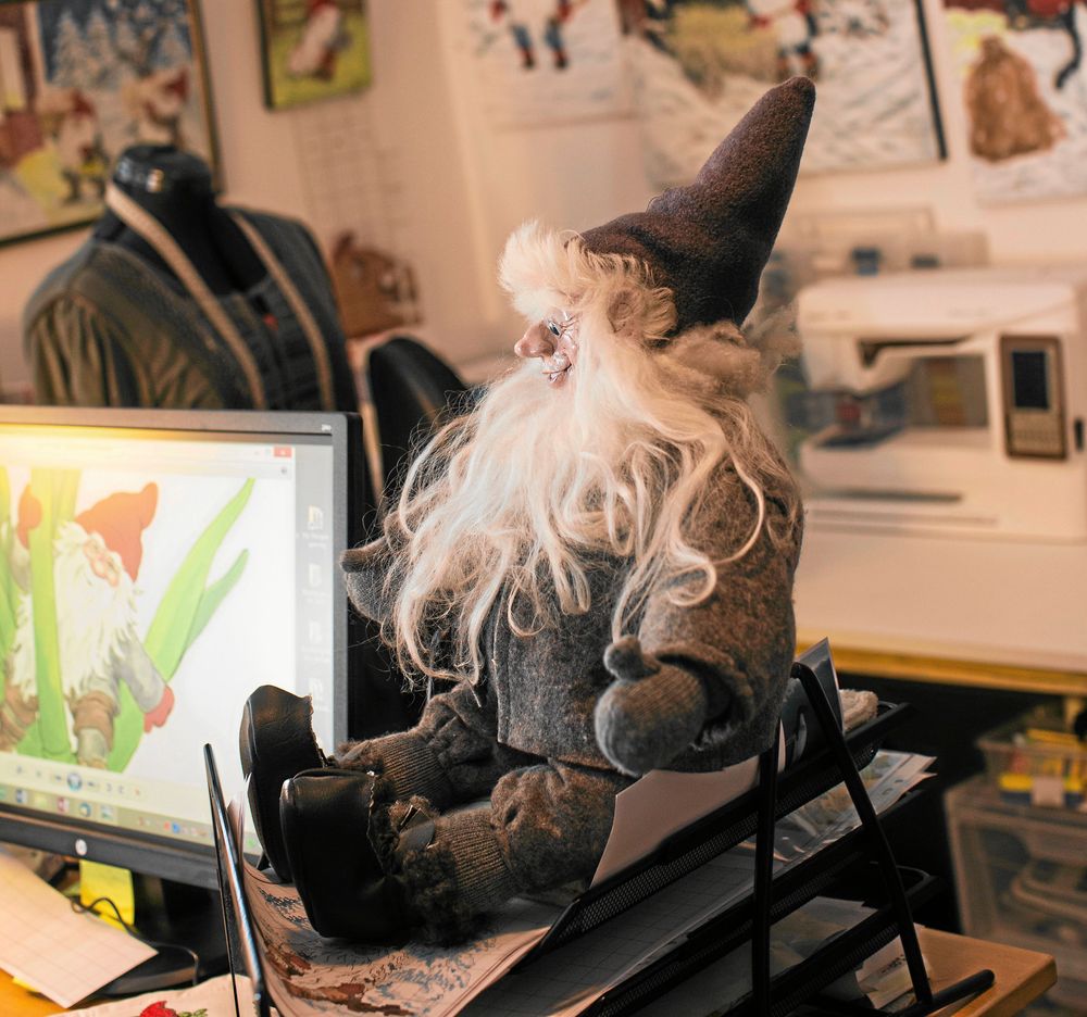 Kerstin skapar mönster via ritprogram i datorn, med en tomtedocka som prydnad bredvid.