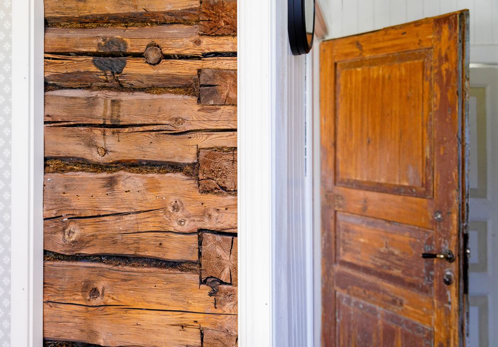 I sovstugan får den gamla timmerväggen titta fram, och dörren är ett återbruk från ett av de gamla husen.