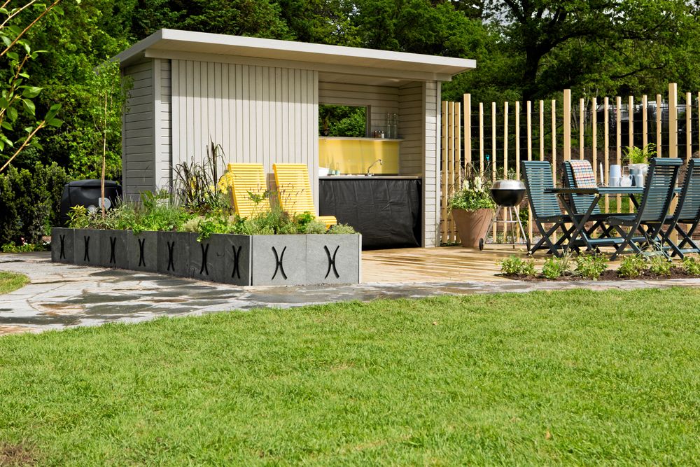 När trädgårdsmästaren Bo Rappne designade en lättskött trädgård blev det här uteköket en del av det. En liten bod med skjutdörr döljer diskbänk och förvaring.