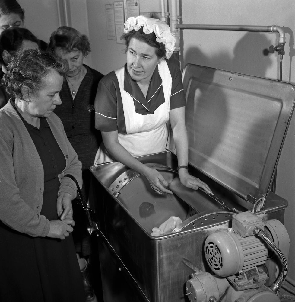 Kvinnorna i husets tvättstuga blir instruerade av en tvättexpert 1956.