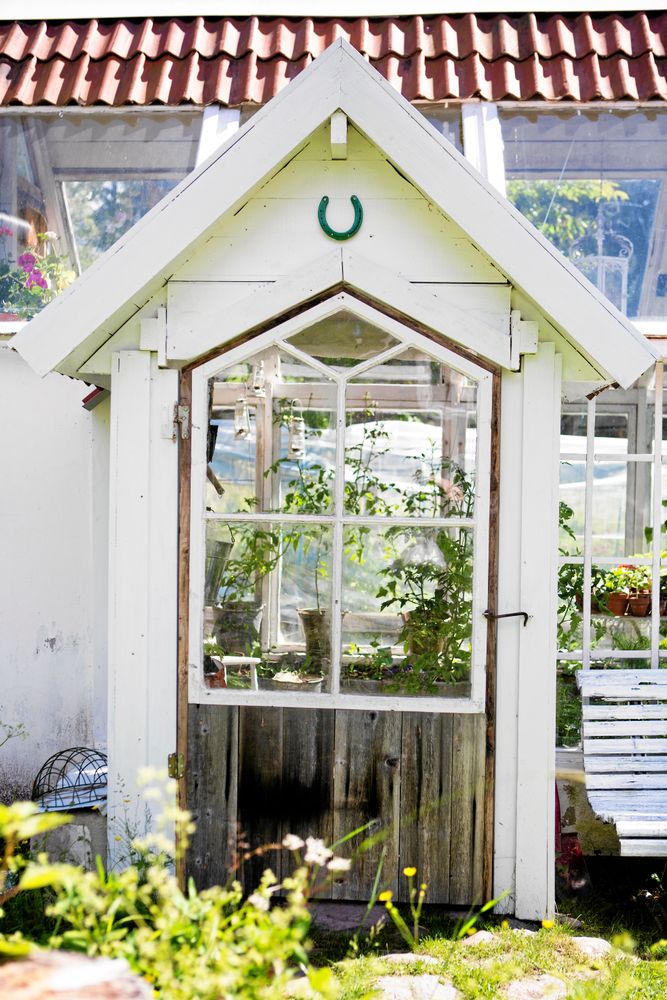 Dörren till den lilla farstun är byggd kring ett gammalt bönehusfönster från trakten.