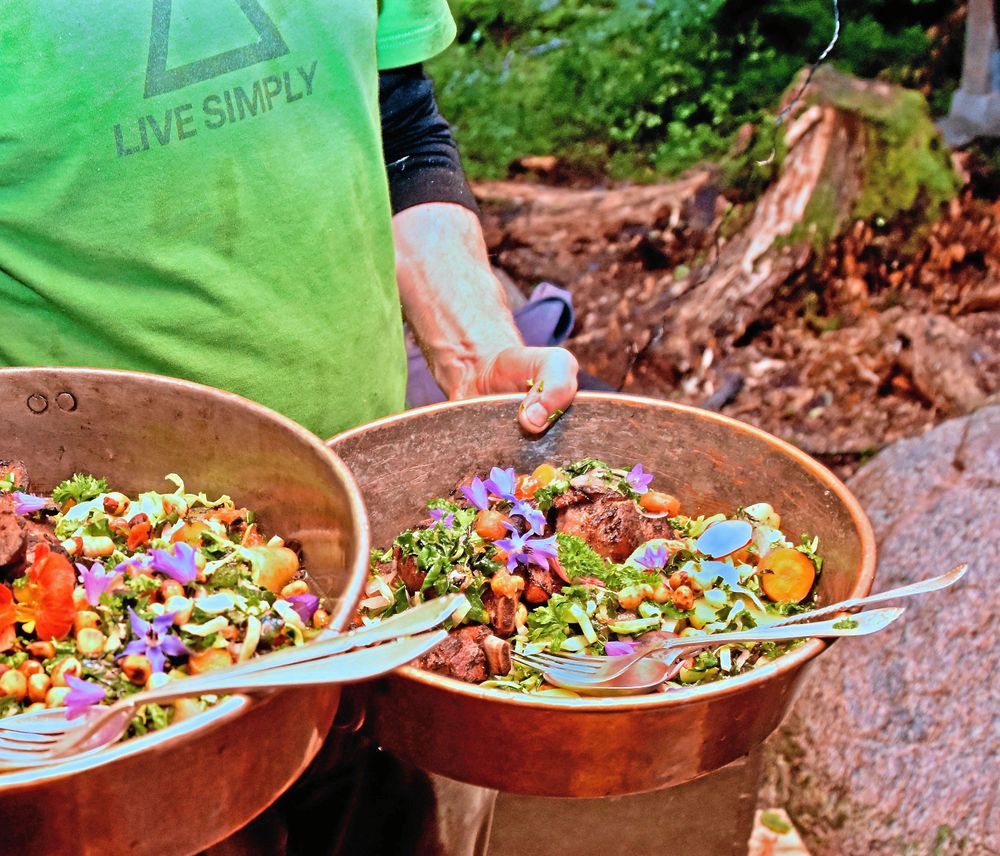 Långkokt kött i sällskap av vilda växter och ätliga blommor utgör kvällens huvudrätt.