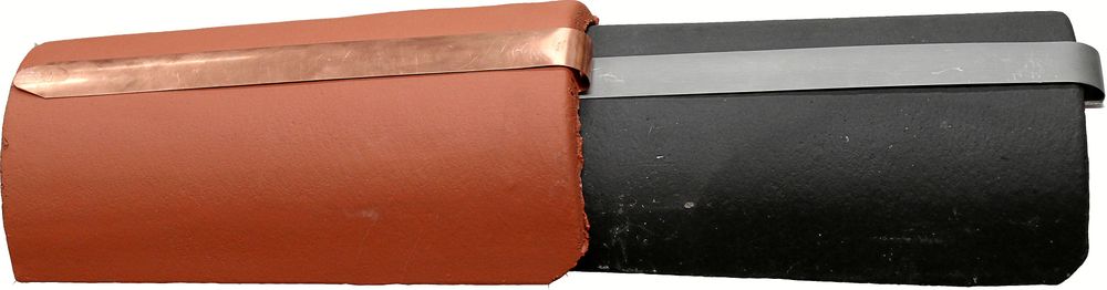 Beslagen i zink eller koppar viks runt nockpannans kant och bankas på plats med en klubba.