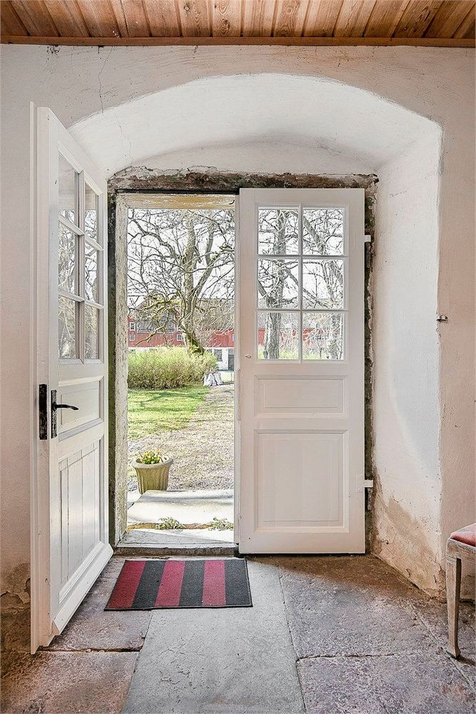 Stengolv och ett vackert valv över entrén i hallen där ytterdörren har försetts med glas och spröjs.