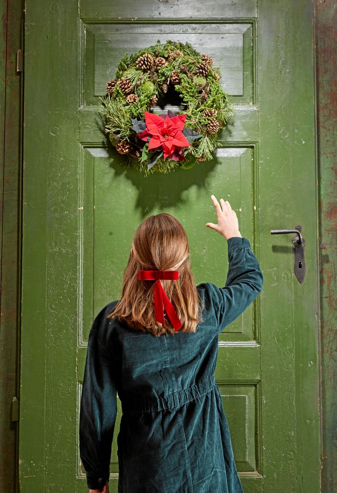 Mörk mossa, kottar och en enda lysande julstjärna i kransen.