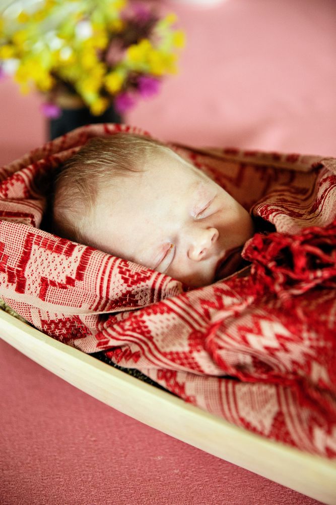 En sömnig Maj bäddas ner i mammas mjölktråg. Det lär inte vara första gången eftersom barn förr ibland fick bada i trågen.