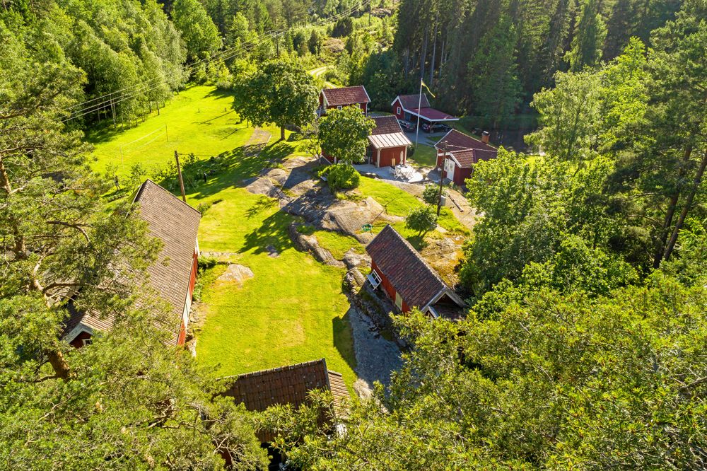 Drönarbild på familjens alla små stugor och ladan i gläntan i skogen. Att riva de små husen på tomten för att bygga ett nytt stort var inget alternativ. Istället har husen alltså blivit fler och fler.