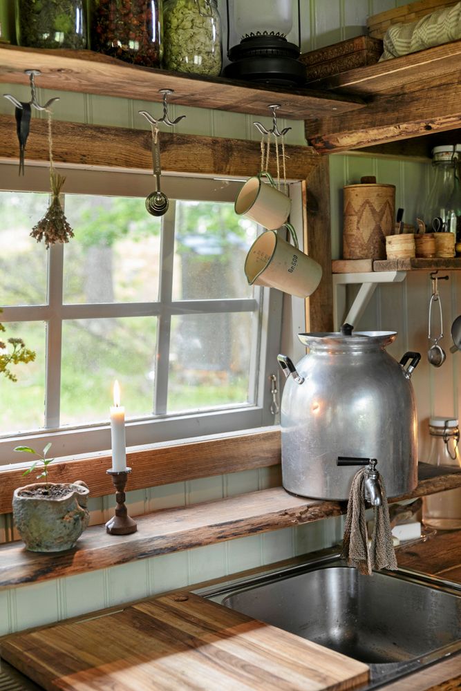 Diskbänken med fin utsikt över hagen och en stor plåtkanna fylld med vatten.