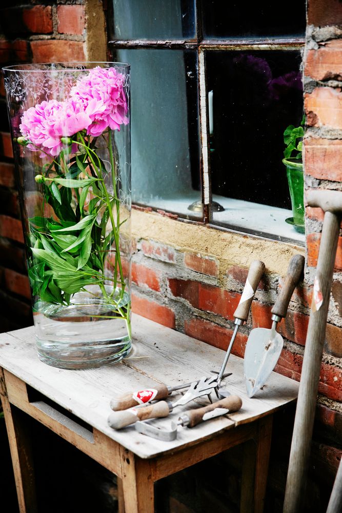 Intill den vackra pionen ligger handsmidda trädgårdsverktyg som Maria säljer i sin butik.