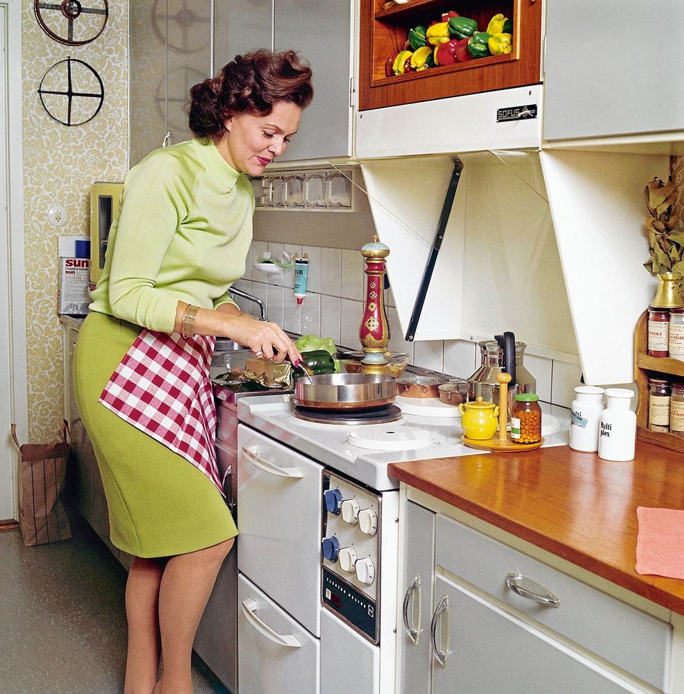 Rör om. Haide Göransson, mannekäng och fotomodell, lagar mat i ett typiskt 60-talskök. Notera – inga lådor bredvid spisen. Detta för att barn inte skulle kunna dra ut, klättra upp och sätta handen på plattan.