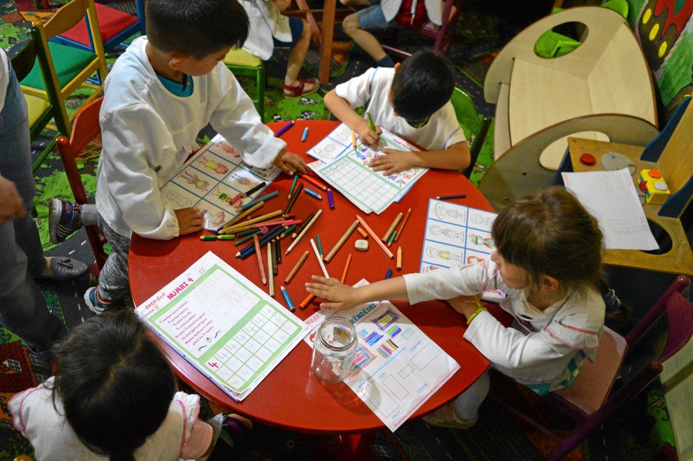 Några av barnen sitter och ritar och pysslar. Foto Martin Falkman