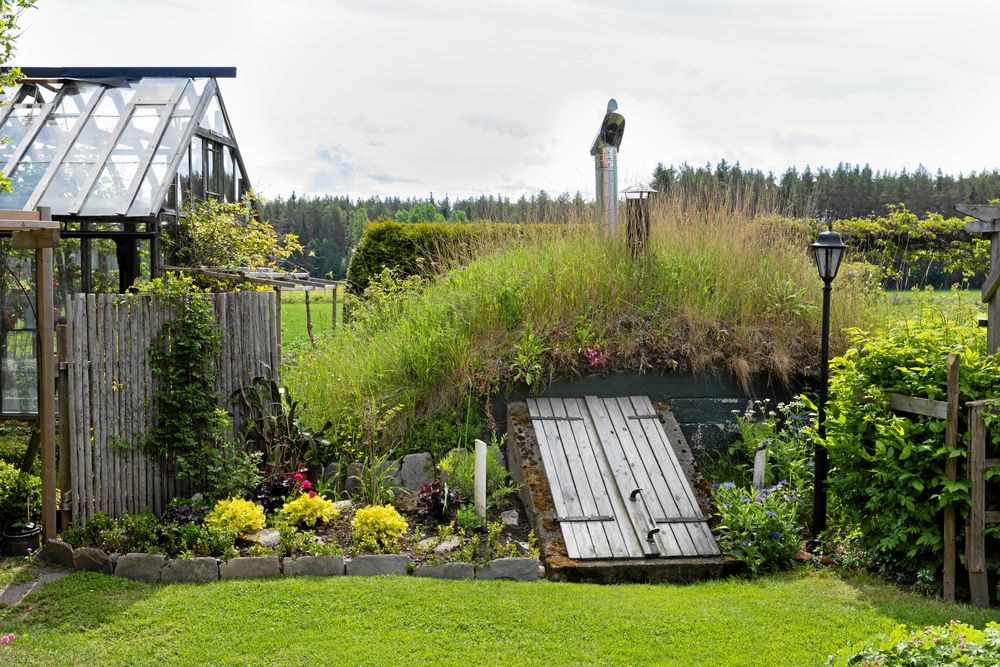 En bakgård kan också vara vacker! Runt växthuset har Eva och Åke samlat praktiska funktioner som jordkällare, planteringsbord och ”barnkammare” åt växterna.