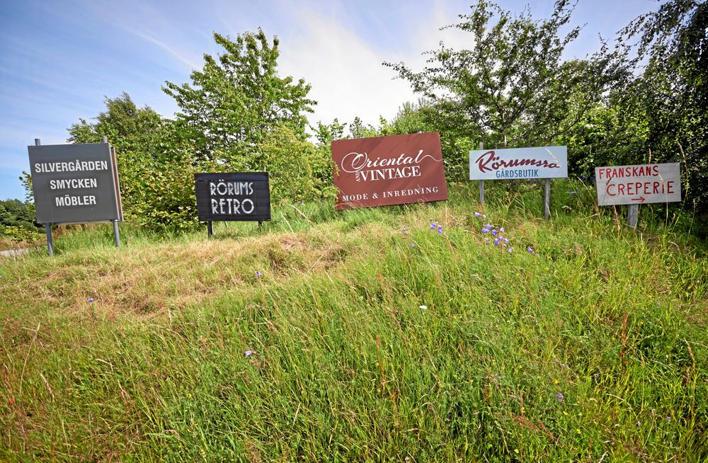 Privata reklamskyltar på en kulle vid Mandelmanns by i Skåne, uppsatta ganska långt från vägen.