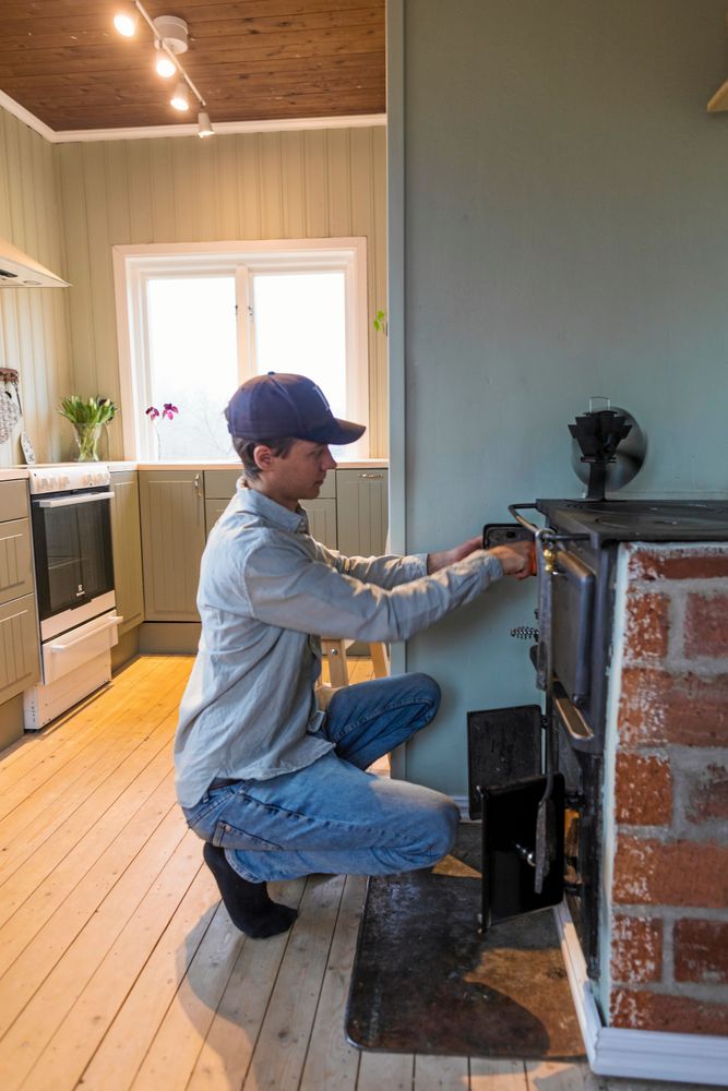 Tom eldar i vedspisen som har återfått sin centrala plats, med nytt värmeskydd som Julia har murat.