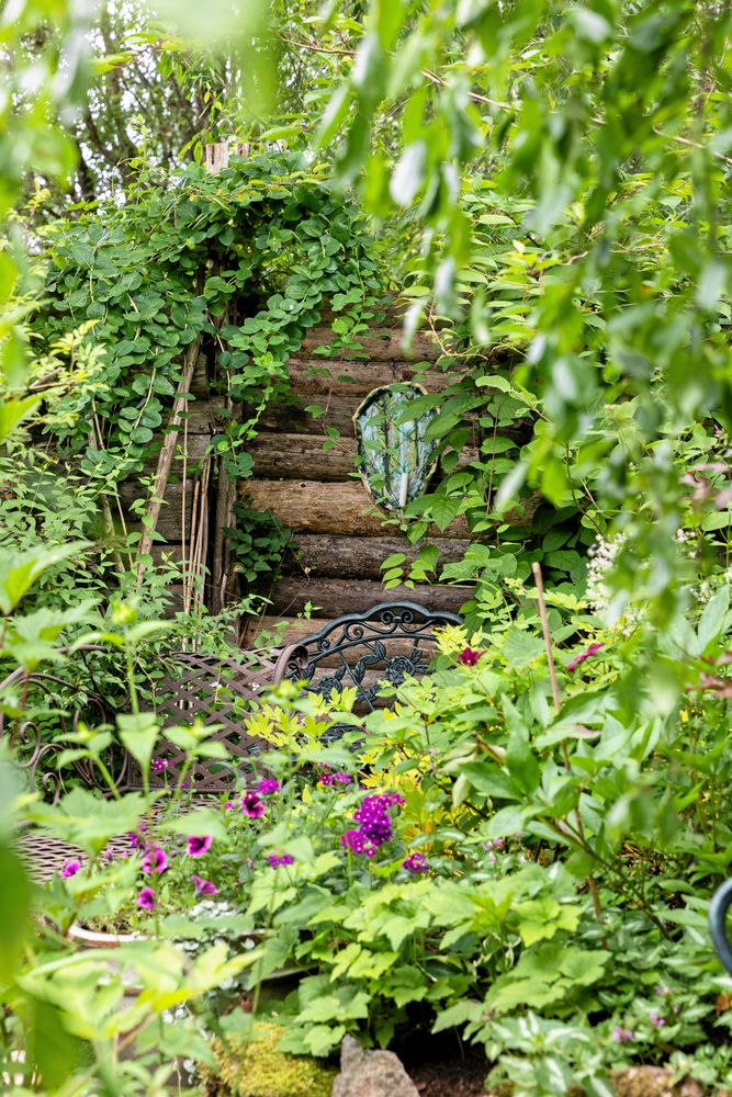 Sagolik och ombonad. Sådan är stämningen i Monicas frodiga trädgård.