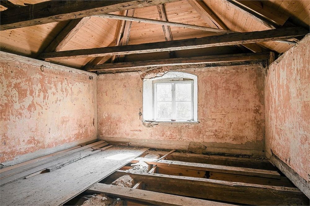 En oinredd vind med träbjälkar och stor potential.