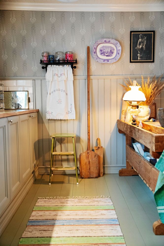 Joar har platsbyggt köksskåpen själv och satt upp den höga grå pärlsponten och den mönstrade tapeten.