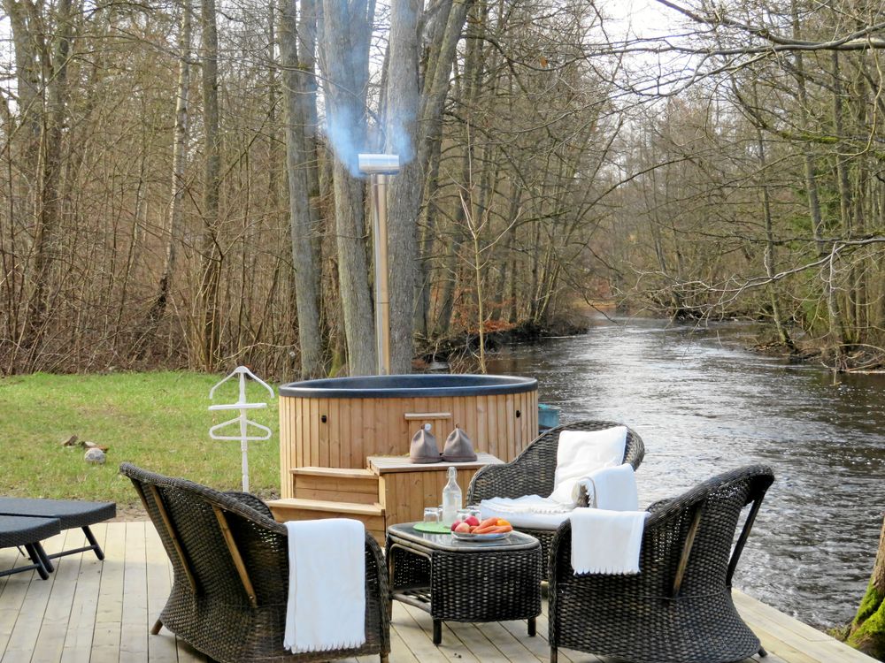 Skön avkoppling i vilstol eller i badtunna under bar himmel intill den brusande ån.