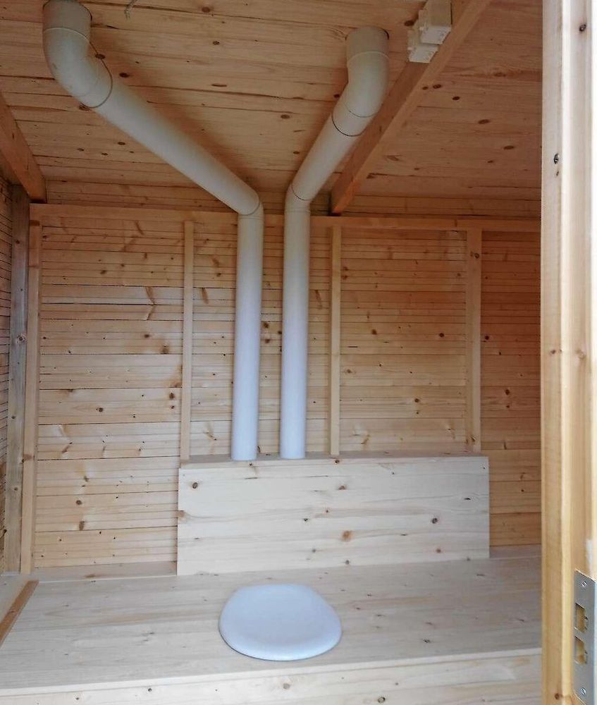 Genom toalettrummet går rören som transponerar varm luft till latrinkärlen.