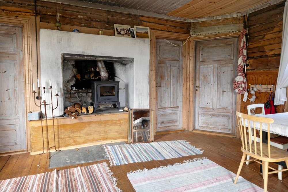 Familjen har inrett ett provisoriskt sommarboende i den gamla bagarstugan. En modern vedkamin är monterad i bakugnen.
