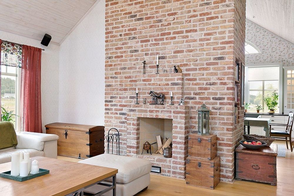 En murad öppen spis som inbjuder till mys framför brasan.