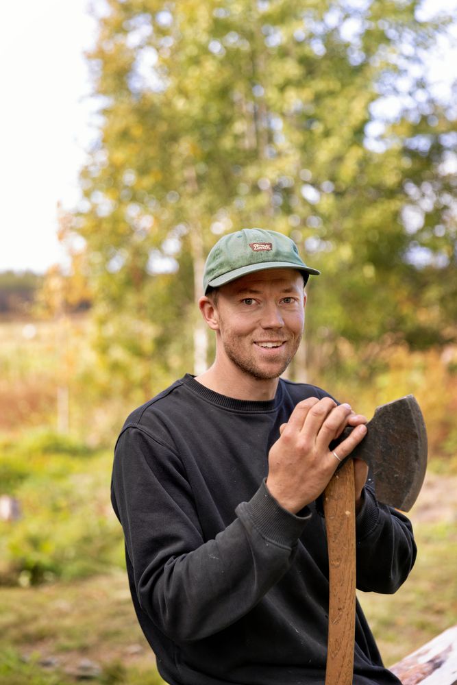 Emil Sundquist med en av sina yxor, denna används till att jämna av timrade ytor.