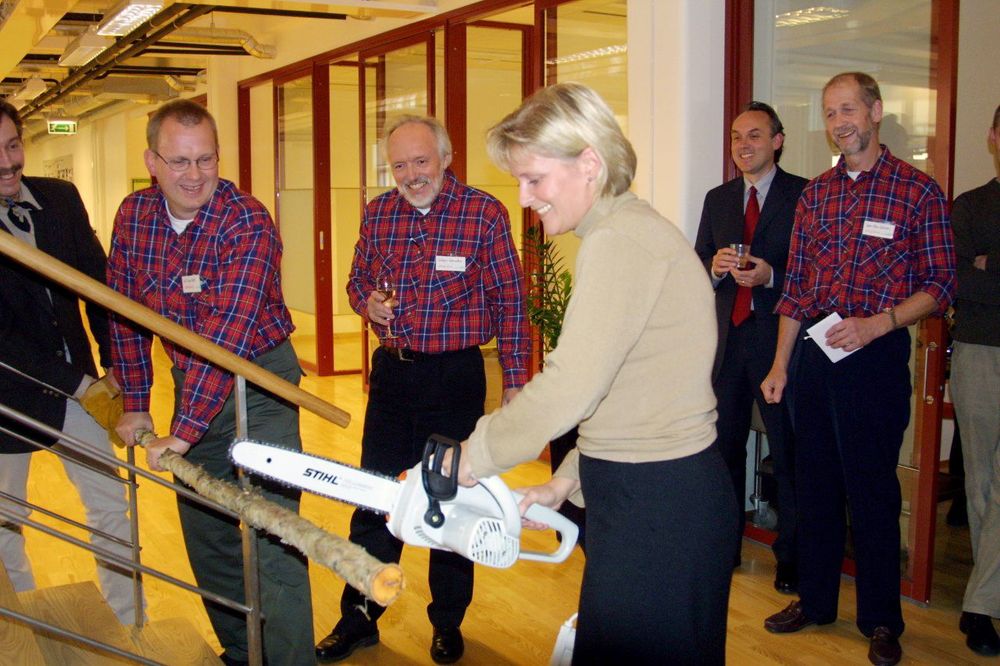 Dåvarande ”skogsministern” Ulrica Messing invigde den nya skogstidningen genom att såga av en trädstam. I bakgrunden Skogslands redaktion i rutiga skjortor, Rolf Segerstedt, Torbjörn Wennebro och Sven-Olov Larsson, samt VD Patrik Widlund i kostym.