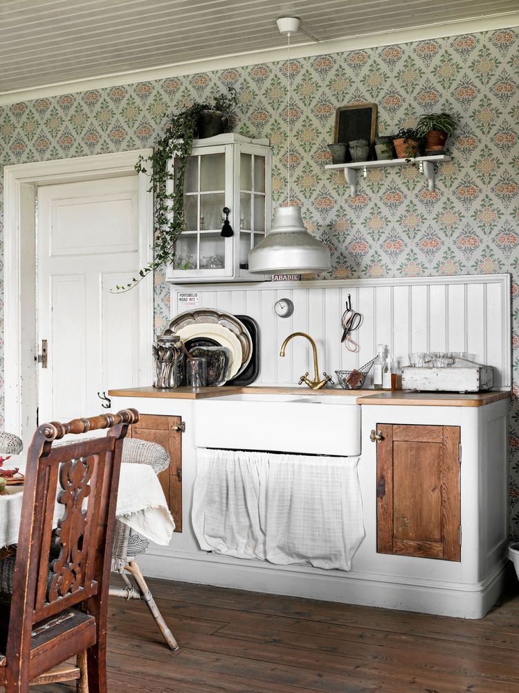 Den engelska diskhon av porslin passar perfekt in i kökets lantliga stil.