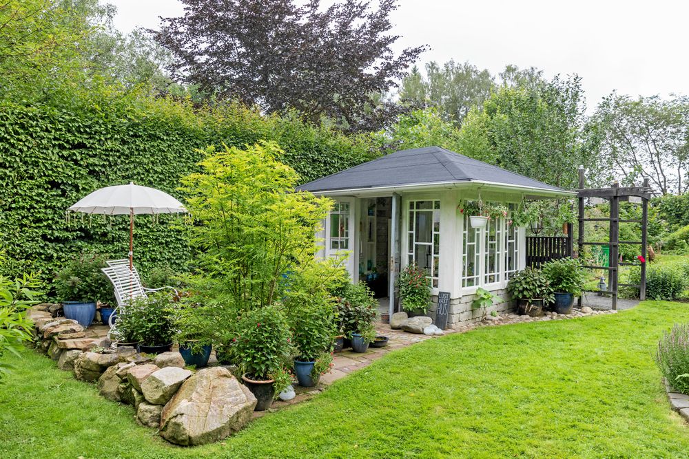 Många besökare tar en paus från blåsten i det nybyggda lustväxthuset bakom den höga bokhäcken och smälter alla intryck.