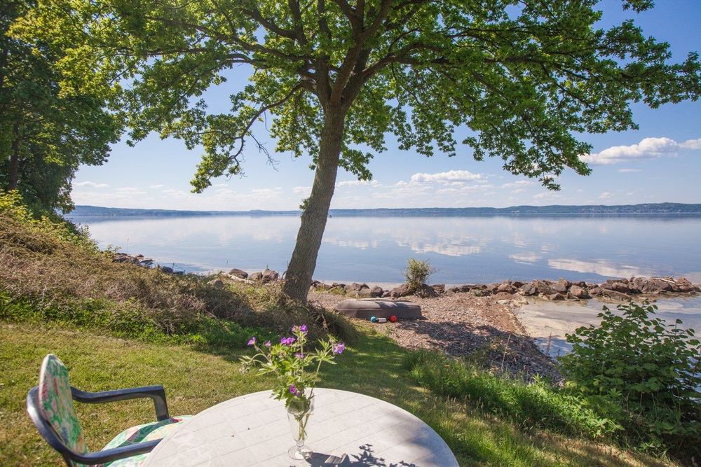 En liten slänt leder ner till en lugn och fridfull strand.