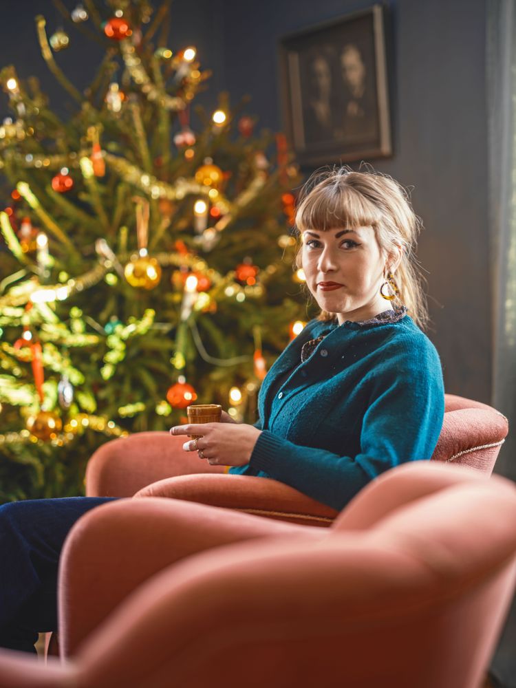 Josefin intill julgranen som paret tar in redan till Lucia och klär traditionellt.