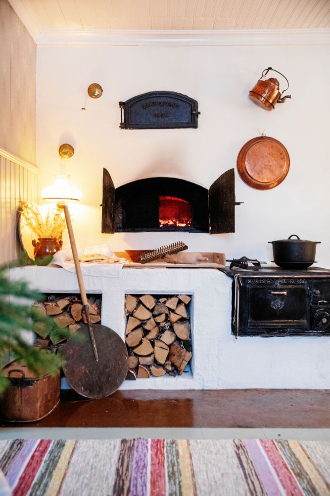 Den rejäla bakugnen och murstocken sprider värmen i huset. Joar har murat bänken med plats för ved.