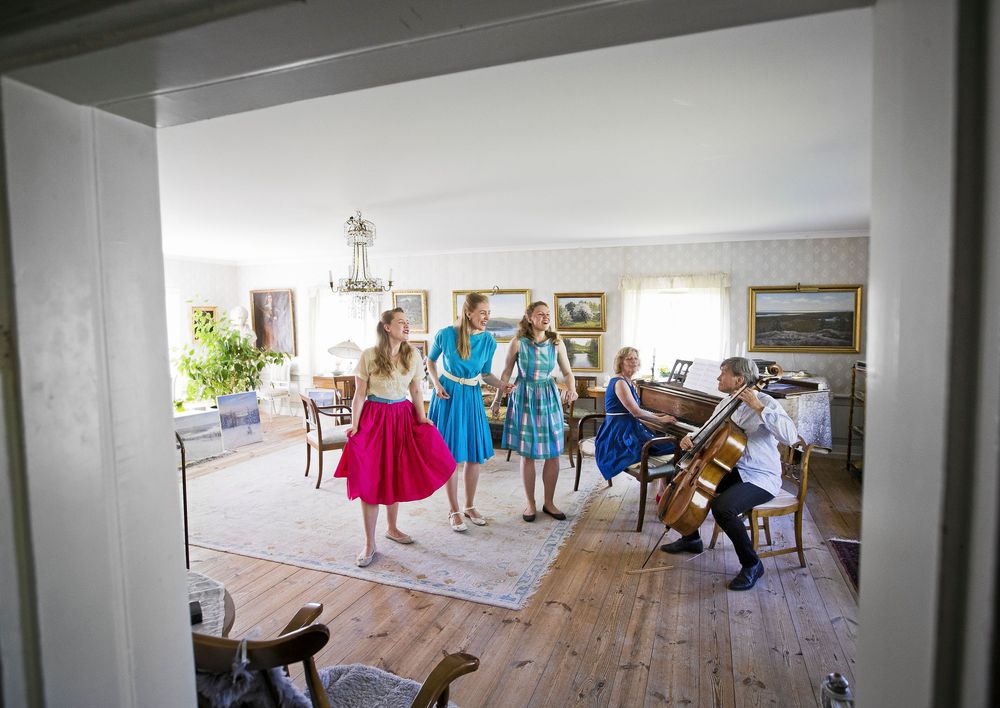 Spontan familjekonsert i salongen: Maria, Emelie och Josefine sjunger och stampar takten medan mamma Ulrika spelar piano och pappa Lars-Inge cello.