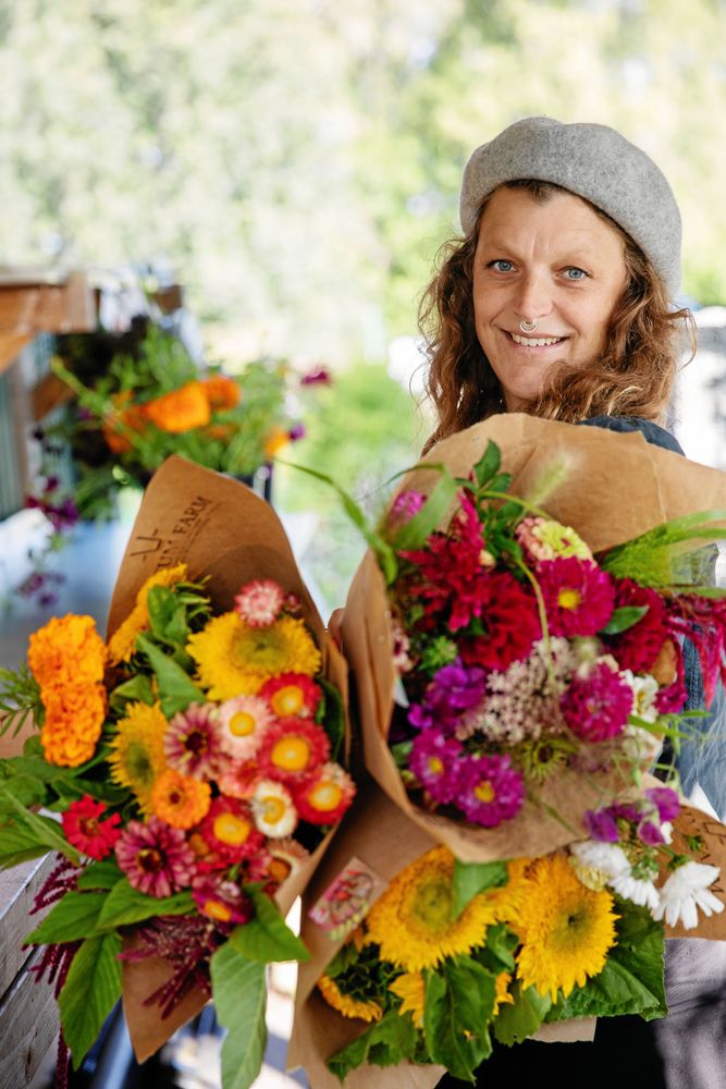 Emelye visar upp två buketter av nyplockade blommor från de egna odlingar.