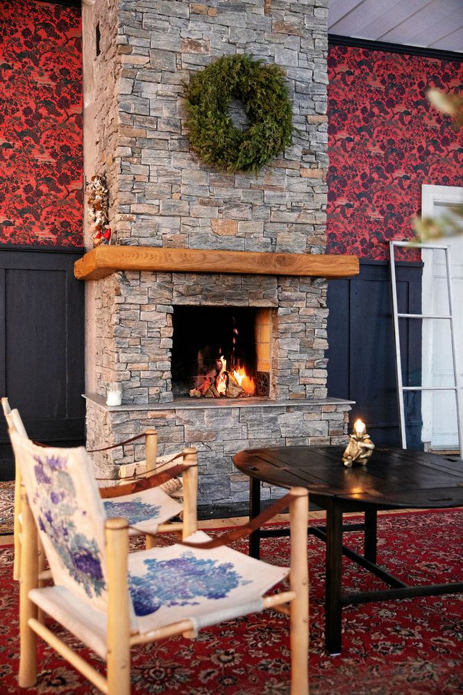 Den imponerande stora öppnas spisen har en matchande, stor krans av tall- gran och enris.