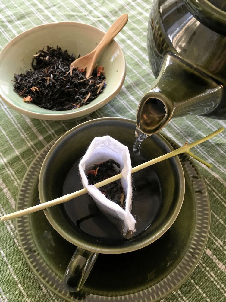 Tvätta och använd igen. Tepåsen av tyg hängs på en liten kvist.