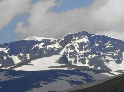 Den snöklädda toppen till väster är Kebnekaises sydtopp. Den mörka till höger är nordtoppen. Bilden är tagen i juli 2011 och då var sydtoppen något över 2 100 meter över havet.